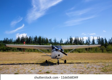 Sechelt Airport, Sunshine Coast, BC, Canada - July 21, 2018: Small Single Engine Airplane, Cessna 172, is parked on the grass during a sunny summer day.