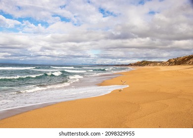 A secluded beach with clouds and big waves