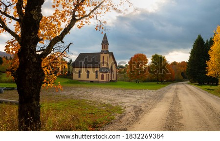 Secluded church in rural northeast United States along a dirt road with no people around in autumn and beautiful fall colors 
