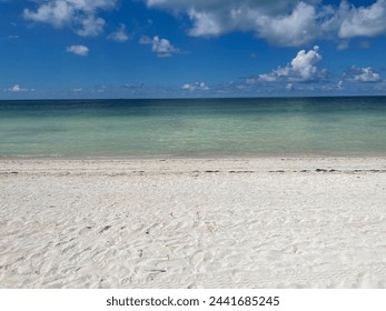 Secluded wide beach shot of sand, water, and sky with no people. - Powered by Shutterstock