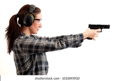 Second amendment, self defence and use of firearms at shooting range concept with a woman aiming a gun and ready to shoot while wearing protective gear isolated on white with a clipping path included