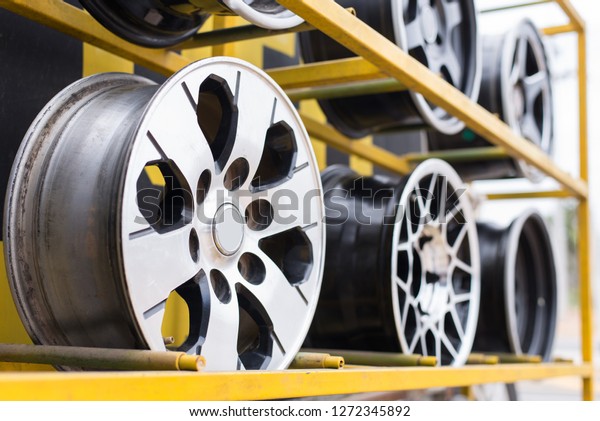 Second\
hand alloy wheels on yellow shelf,Selective\
focus.