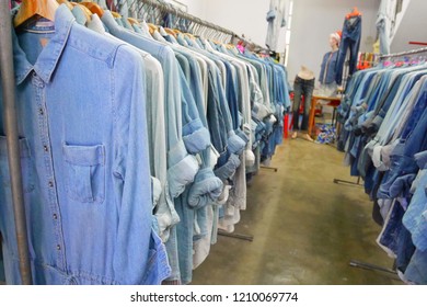 At The Second Hand Clothes Shop, Many Jeans Shirt And Trousers Are Hanging On The Clothes Line.