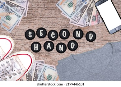 Second Hand Lettering Next To Shoes, T-shirt, Phone And American Dollars. Concept Showing The Sale Of Used Clothes Online