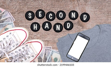 Second Hand Lettering Next To Shoes, T-shirt, Phone And American Dollars. Concept Showing The Sale Of Used Clothes Online