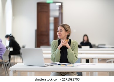 Second Higher Education. Happy Middle-aged Woman Adult Learner Watching Educational Webinar Via Laptop, Sitting At Library Desk, Studying In University As Mature Student, Enjoying Studying For Degree