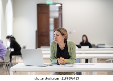 Second Higher Education. Happy Middle-aged Woman Adult Learner Watching Educational Webinar Via Laptop, Sitting At Library Desk, Studying In University As Mature Student, Enjoying Studying For Degree