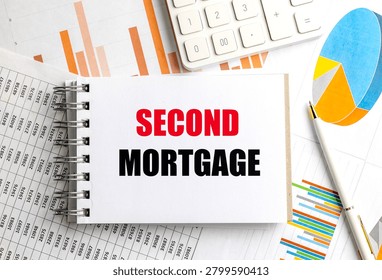 Second mortgage concept on notepad with financial charts calculator and pen representing home equity lending refinancing debt. 