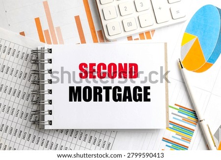 Second mortgage concept on notepad with financial charts calculator and pen representing home equity lending refinancing debt. 