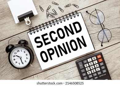 Second Opinion text on an open notepad on a light table near a calculator and glasses - Shutterstock ID 2146508525