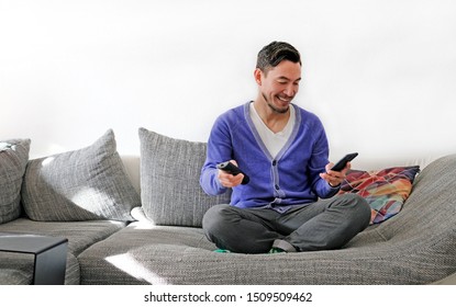 Second Screen - Smiling Man With Remote Control And Smartphone