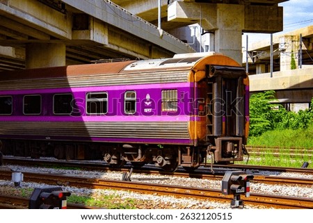 A second-class air-conditioned sleeper train by Daewoo basking in the late morning sun at the LD yard near Krung Thep Aphiwat Central Terminal in Bangkok, Thailand. The scene showcases the warmth of a