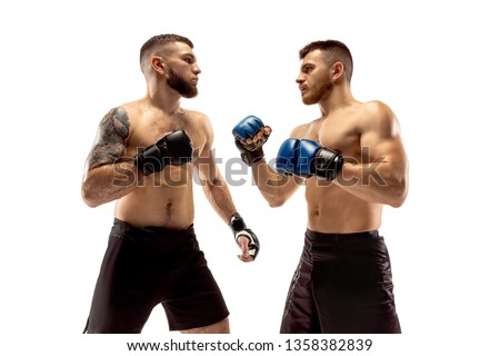 Seconds before war. Two professional fighters posing isolated on white studio background. Couple of fit muscular caucasian athletes or boxers fighting. Sport, competition and human emotions concept.