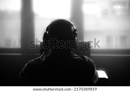 Secret agent listens on the reel tape recorder. Officer wiretapping in headphones. Spying of conversations. Intelligence gathering. Espionage concept. Report information to superiors. Foto stock © 
