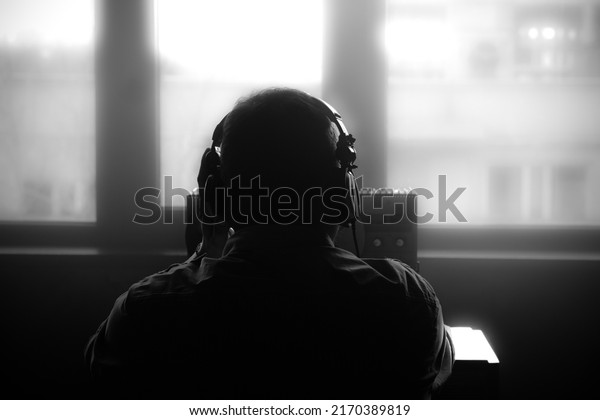 Secret agent listens on the reel tape\
recorder. Officer wiretapping in headphones. Spying of\
conversations. Intelligence gathering. Espionage concept. Report\
information to\
superiors.