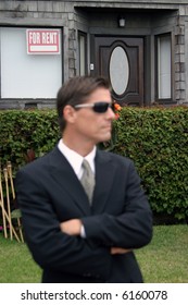 A Secret Agent Wears Dark Sunglasses And A Dark Suit While He Looks Around To Protect His Employer While At A High Profile Event