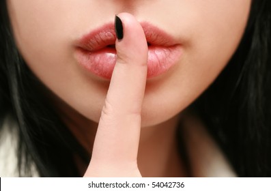 secret. beautiful girl with his finger near the lips
