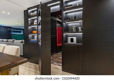 Secret cigar room with red velvet high back bench seating black cabinets glass table chairs and wine storage - Shutterstock ID 2102494420
