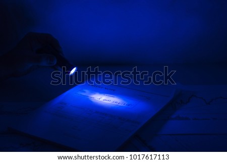 Secret documents reading. Ultra violet light abstract photo. Documents on table under ultra violet light.