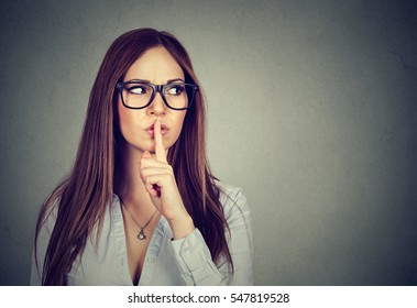 Secret Girl. Woman Saying Hush Be Quiet With Finger On Lips Gesture Isolated On Gray Wall Background.