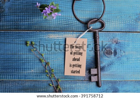 The secret of going ahead is getting started quotation. Life,  success concept. Vintage key on wooden background