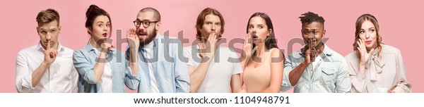 Secret, gossip concept. Young men and women\
whispering a secret behind hands. Business people isolated on\
trendy pink studio background. Young emotional menand women. Human\
emotions, facial\
expression