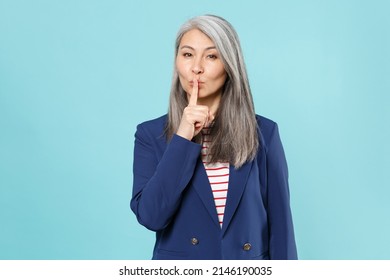 Secret Gray-haired Business Woman In Blue Suit Isolated On Blue Background Studio. Achievement Career Wealth Business Concept. Mock Up Copy Space. Say Hush Be Quiet With Finger On Lips Shhh Gesture