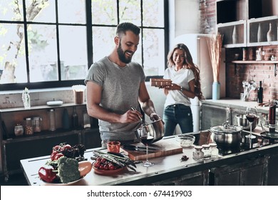 Secret ingredient is love. Beautiful young couple preparing a healthy meal together while spending free time at home - Powered by Shutterstock