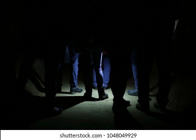 The Secret Meeting Group Feet Of People In The Underground Dark, Stalker Esoteric, Highlighted By A Lantern - A Secret Meeting At Night In The Dungeon