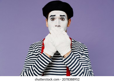 Secret strict silence young mime man with white face mask wears striped shirt beret covering mouth with hands do not want to speak isolated on plain pastel light violet background studio portrait
