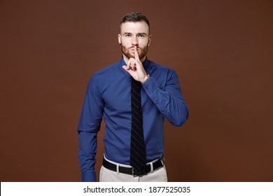 Secret Young Business Man In Blue Shirt Tie Say Hush Be Quiet With Finger On Lips Shhh Gesture Looking Camera Isolated On Brown Background Studio Portrait. Achievement Career Wealth Business Concept