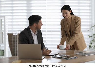 Secretary Bringing Coffee To Her Boss In Office