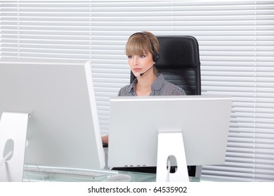 Secretary With Headphone And Multiple Monitors In Her Clean Office