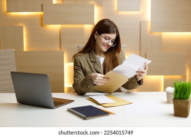 The secretary looks through the mail with documents, the woman manager checks the accounts. - Shutterstock ID 2254015749