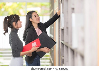 Secretary And Purchasing Manager Helping To Sort Out Company Files And Filing Account File In A Modern Office Shelves Room. Setup Studio Shooting.