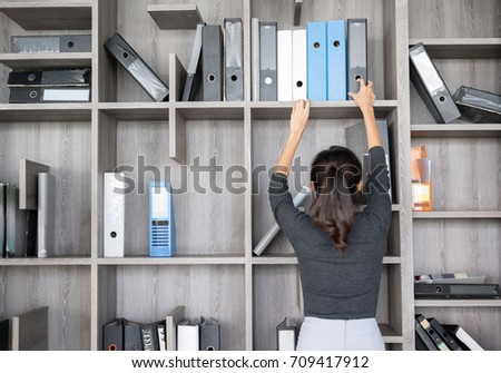 Secretary or Purchasing Manager  in a modern Office shelves room. Setup studio shooting.