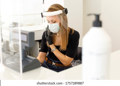 Secretary Who Works In A Computer Shop Is Protected By A Mask, Visor And Plexiglass Screen