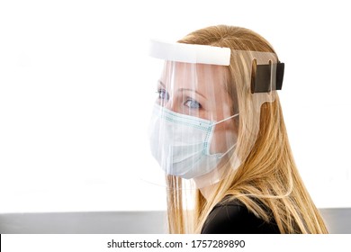 Secretary Works On The Computer Protected By A Visor, Surgical Mask And Plexiglass Screen