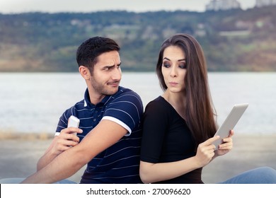 Secretive Couple with Tablet and Smartphone - Young adult couple has privacy problems with modern technology 
