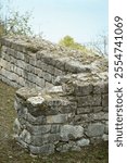 A section of the ancient Roman fortress wall of Sexaginta Prista, with weathered stone blocks covered in moss and vegetation, highlighting historical significance and ancient construction techniques.