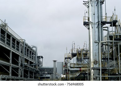 Section Of The Distillery Plant Of A Modern Oil Refinery With A Fractionating Column, Tanks And Pipelines