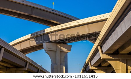 Section of elevated higway with several levels against a bright blue sky