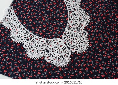 A Section Of Fabric With A Pattern And A White Lace Collar For The Dress.