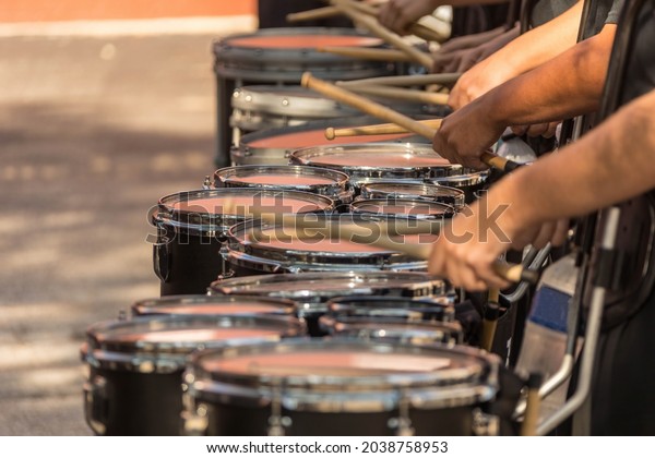 a section of a marching band drum line warming up\
for a parade