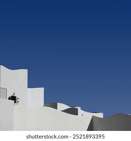 Section of the wave shaped top of a large white building under blue sky