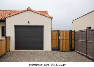 sectional tilting black garage door and entrance gate of modern new house - Shutterstock ID 2218955619