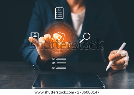 Secure digital document management concept as business professional reviews checklists, verifies protected files on virtual shield interface with search, audit icons, supporting compliance, control.