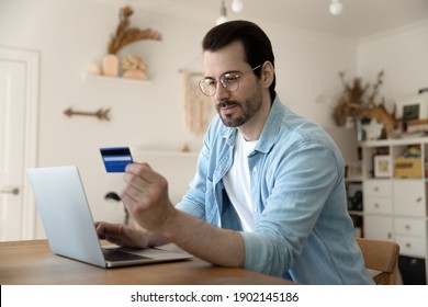 Secure payment. Attentive young businessman operating personal bank account from home computer. Focused male customer input cardholder information online to buy purchase goods services prepay order