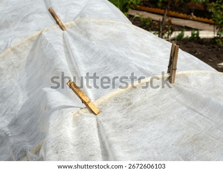 Securing the covering material to the arches using clothespins