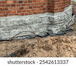 Securing the foundations of existing, old buildings against moisture. Excavation, cleaning, reinforcement of joints, insulation and backfilling with earth.